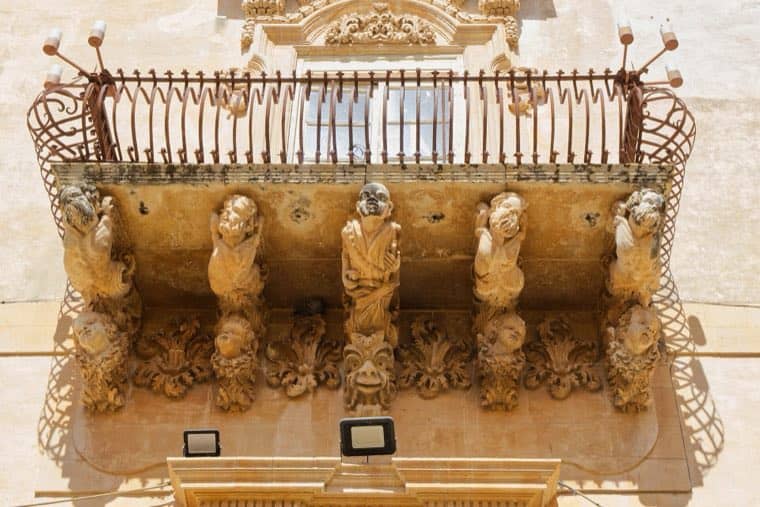A balcony of Palazzo Nicolaci in Noto, figures carved in stone